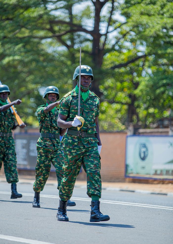 Soldiers marching in a military parade with camouflage uniforms outdoors.