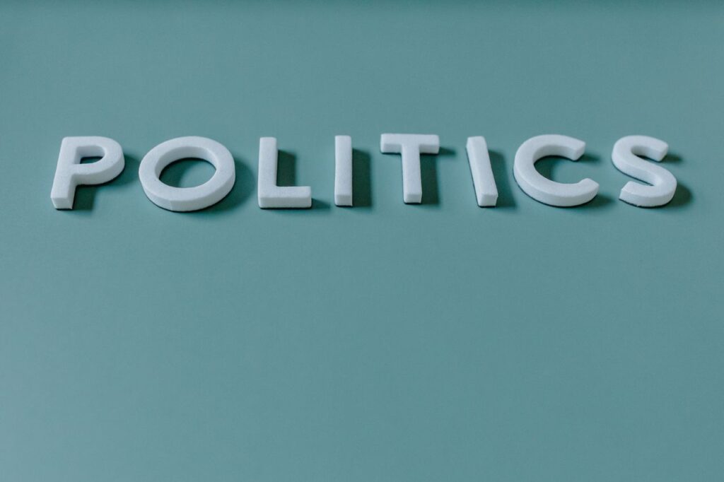 Close-up image of the word 'Politics' against a teal green background, highlighting political themes.